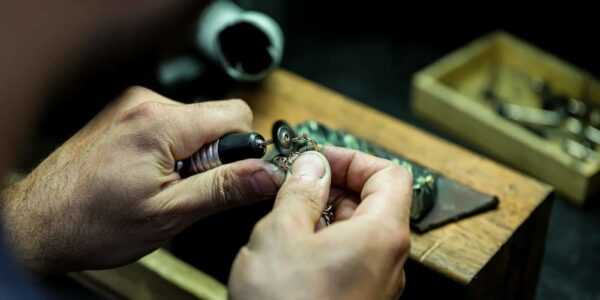 person wearing silver ring with black gemstone